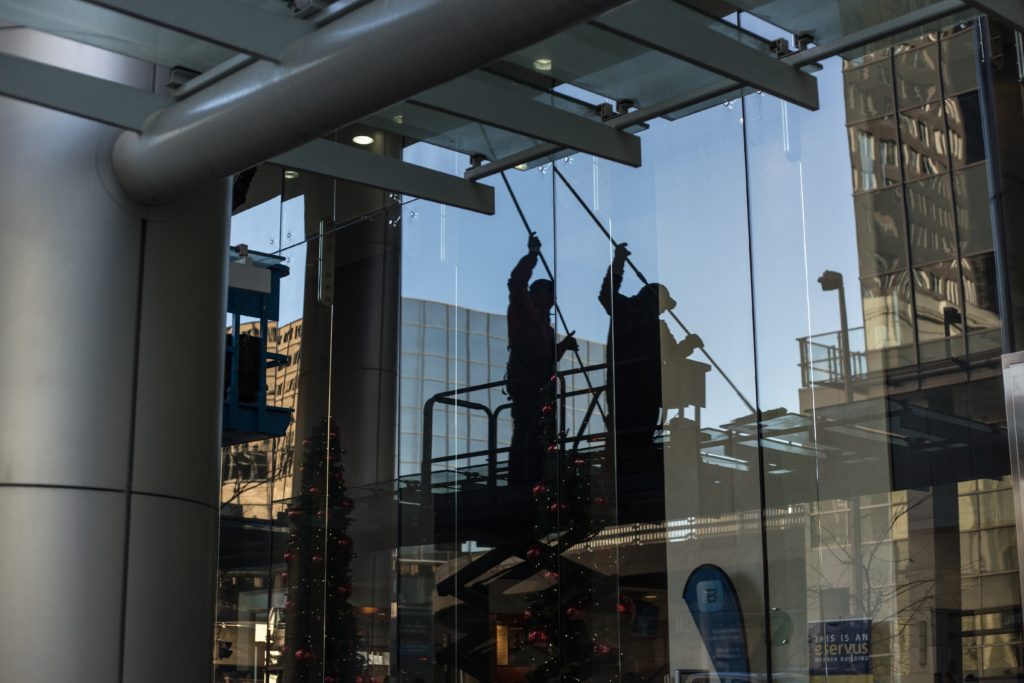 reflection of window washers on a high rise