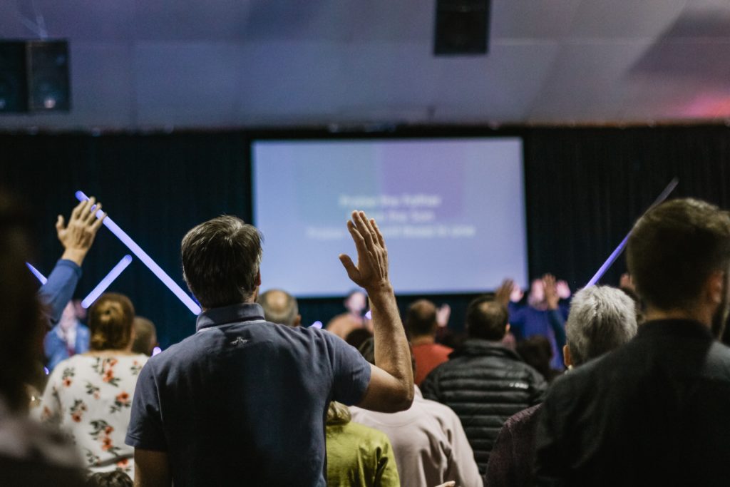 shallow focus photo of person raising right hand